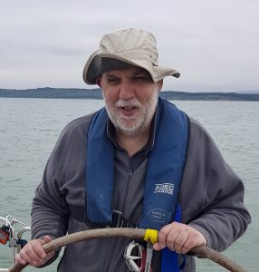 Alan Mckee at the wheel of the yacht