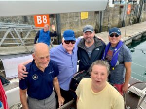 Crew of Sea Vision Week One, Denis, Nathalie, Ramin, Toby in the cockpit of yacht Wheal Go. In the background is skipper Peter Sandover