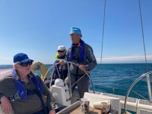 Denis helming the boat with Viv in background