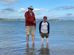 Vijay and Tim standing in the shallows at Weymouth Bay