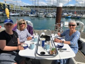 Pic shows Lorraine, Diane and Sue seated around cockpit table enjoying a healthy breakfast in the sunshine.