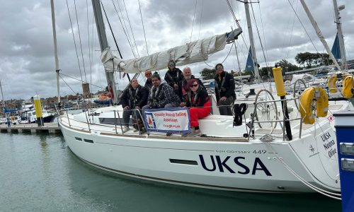Photo of the UKSA boat with all of the crew lined up and looking at the camera in Yarmouth harbour. The visa-gb dodger is visible